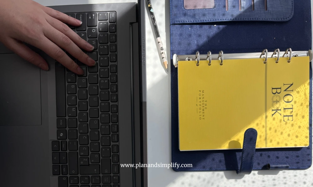 Girl working from home on a laptop with a notebook next to it